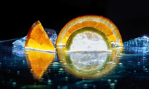Transparent slices of fresh oranges and lemons on the glass with ice
