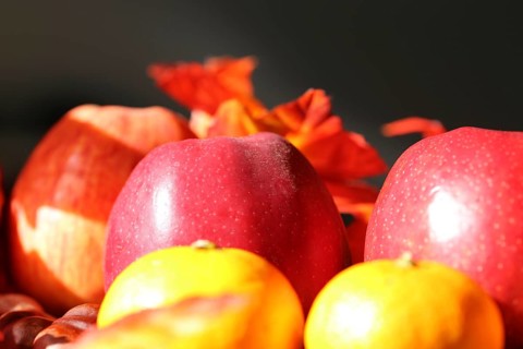 Apples and mandarins on a rustic wooden table as an autumnal motif