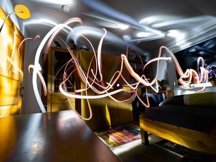 An Abstract image taken in a dark room and painting with light, by a person holding a hand held
