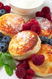 Breakfast, cottage cheese cakes, with fresh berries, and sour cream, top view, close-up, no people