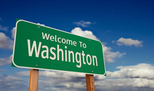 Welcome to washington green road sign over blue sky with some clouds