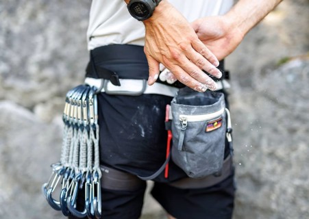 A climber uses so-called chalk (magnesium) in front of climbing a route on the rock, in Morsbach,