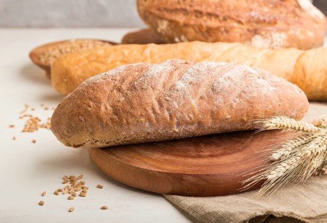 Different kinds of fresh baked bread on a white wooden background. side view, close up, selective