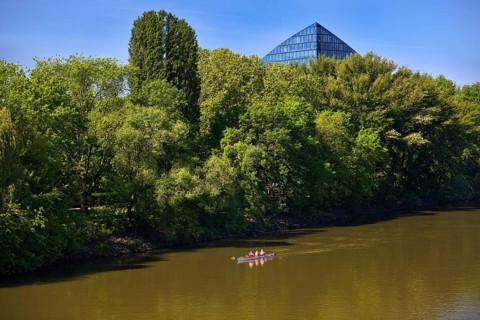 The river Main with a sports boat and the tip of the Main Triangle in Frankfurt-Sachsenhausen,