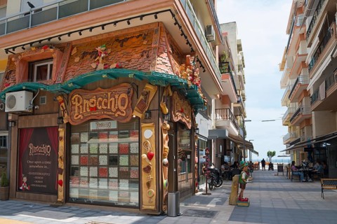 Exterior view of a shop with a unique fairy-tale style façade on a street, shop with sweets,