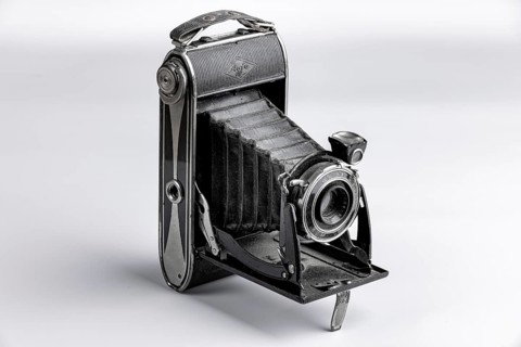 Black bellows camera unfolded on a white background