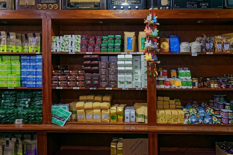 An assortment of different tea products on wooden shelves in a shop, tea cultivation and production