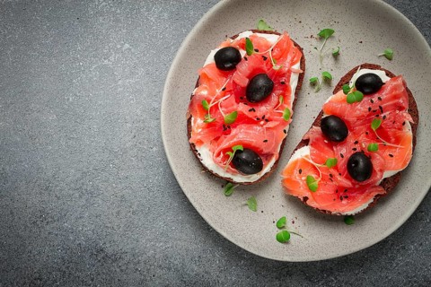 Sandwiches with red fish, cream cheese, olives and microgreens, breakfast