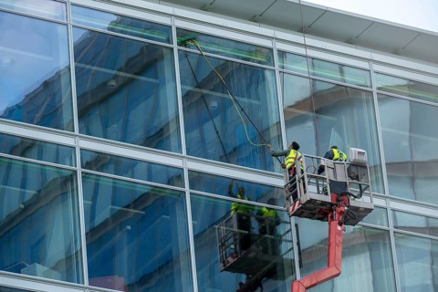 Window cleaner, building maintenance, facade cleaning, on a cherry picker, in Düsseldorf, North