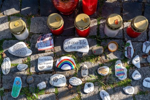 Candles and stones with inscriptions in memory of the dead of the corona pandemic, stickers from