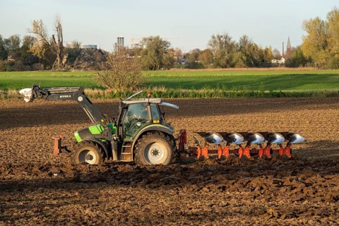 Farmer ploughing a field, tractor with plough, near Neuss, North Rhine-Westphalia, Germany, Europe