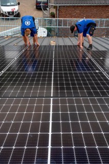 Installation of solar modules on the roof of a barn on a farm, over 240 photovoltaic modules are