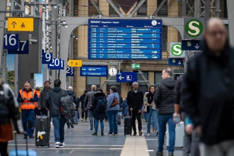 Station concourse, display board, timetable, travellers in the main station of Frankfurt am Main,