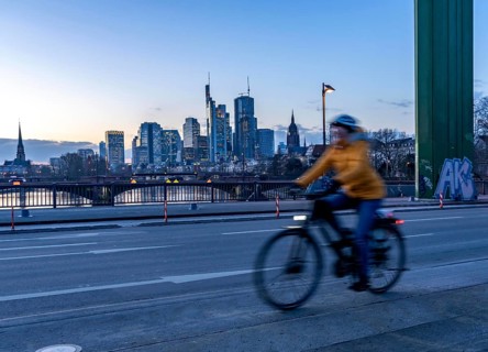 Skyline of the city centre of Frankfurt am Main, cyclist on the raft bridge, dusk, river Main,
