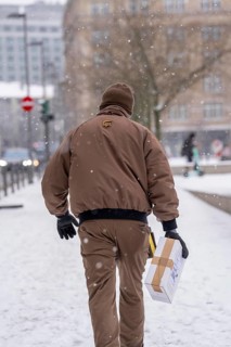 Winter in Frankfurt, UPS employee brings a parcel to a customer, on foot, because of the winter