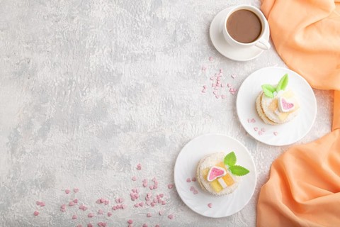 Decorated cake with milk and coconut cream with cup of coffee on a gray concrete background and