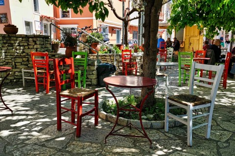 Terrace under trees, colourful chairs and tables in front of a café, small town Leonidi, Leonidio,