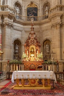 Artistic baroque altar in a church with candles and religious motifs, Granada