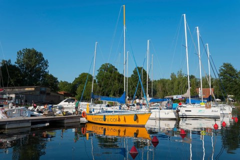 Sailing boats in the harbour with red buoys and a clear blue sky in summer, Gizycko,