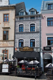 Cosy restaurant in a historic building with a decorative façade and parasols in the city centre,
