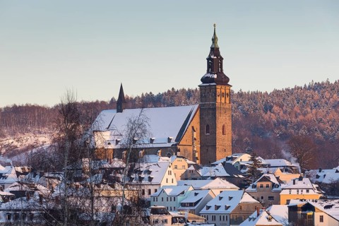 Winter town view with St Wolfgang's Church and Gleesberg in the evening light, Schneeberg in the