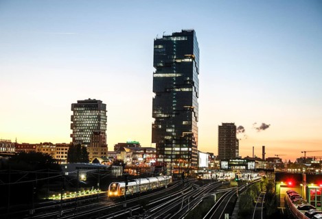 Sunset at the Modersohn Bridge, view of railway tracks, trains and the 140 metre high Amazon office