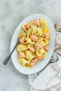 Papardelle pasta, in creamy sauce with salmon, natural light, lifestyle, homemade, on a gray