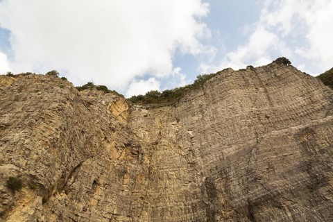 Low angle view of rugged and steep cliff with cut rock face, Sorrento, Campania region, Italy,