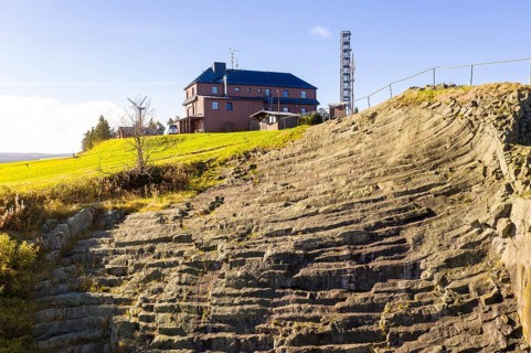Basalt outcrop from a former quarry on the Hirstsein with mining hut, Erzgebirge, Marienberg