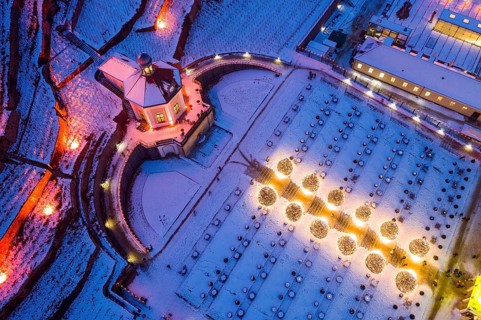 Aerial view of Wackerbarth Castle Park with Belvedere and vineyards with snow and Christmas lights,