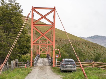 Traditional orange suspension bridge below waterfall Mellizo south of Cochrane, weight limit 1.5 t,