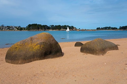 Beach with large rocks and a sailing boat in the background, Baie de Sainte-Anne, Trégastel,