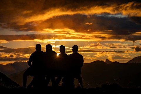 People marvelling at Montafon mountains with dramatic cloudy sky at sunset, Tschagguns, Rätikon,