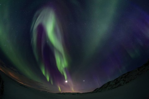 Green northern lights, aurora borealis over snowy mountains, volcanic, winter, moon, fisheye shot,