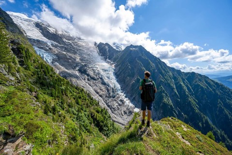 Mountaineer in front of impressive mountain landscape with glacier, view of glacier Glacier de