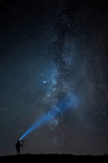 Photographer with tripod and headlamp light in a meadow with starry sky, Mindelheim, Unterallgäu,