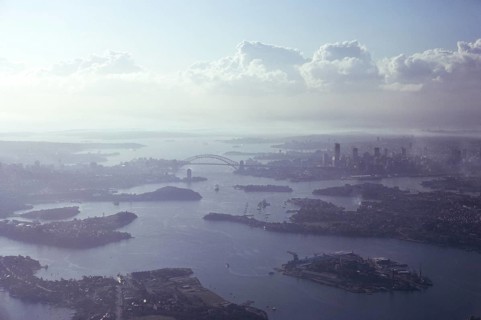 Oblique aerial view of the harbour, the bridge and the city centre skyline, Sydney, Australia 1974