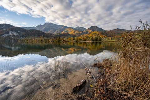 On the shore of Lake Lake Kochel with reflection, autumn landscape with mountain peaks Herzogstand