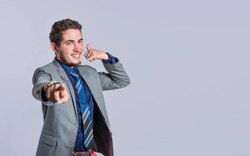 Man making phone gesture with his fingers, Hispanic young man making phone gesture and pointing to