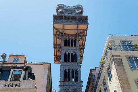 Historic Gothic style lift in Lisbon, rising between old buildings and standing out against a clear