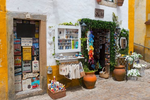 Small shop in a cobbled alley offering souvenirs and colourful handicrafts, R. Direita, Óbidos,