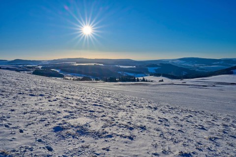 Hilly, snow-covered landscape under bright sun and blue sky, winter, Wasserkuppe, Gersfeld, Rhön,