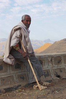 In the highlands between Mekele and Lalibela, elderly man with stick waiting by the road, Ethiopia,