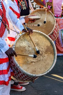 Drummers with rustic and colorful wooden drums at an Afro-Brazilian cultural event on the streets
