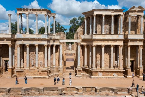 Front view of an ancient Roman building with columns, people exploring the historic site in fine