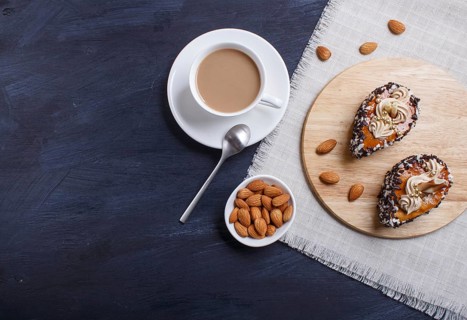 Cakes with chocolate chips and cream decorations on wooden board on black wooden background. with