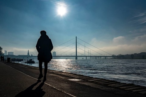 Dense fog is slowly lifting, riverside promenade on the Rhine near Düsseldorf, in front the