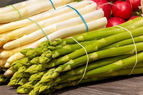 Green asparagus and white asparagus decorated on a rustic wooden table