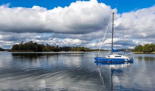 Yacht on Galve lake, Lithuania with blue cloud sky on the background