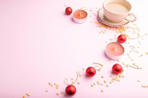 Christmas or New Year composition. Decorations, red balls, cup of coffee, on a pink paper